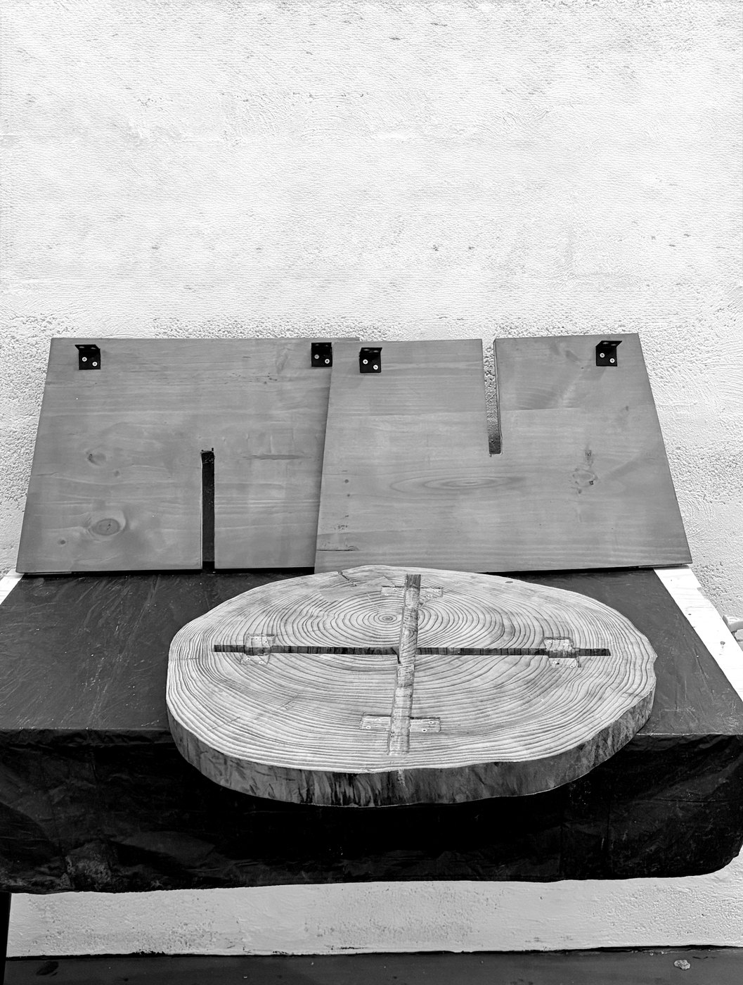 The cross-marked log round in the atelier